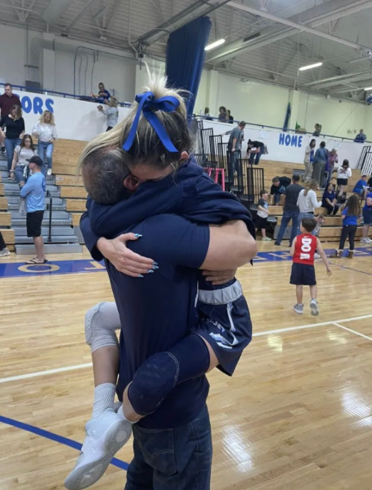 Michelle embracing her father on the court. 
