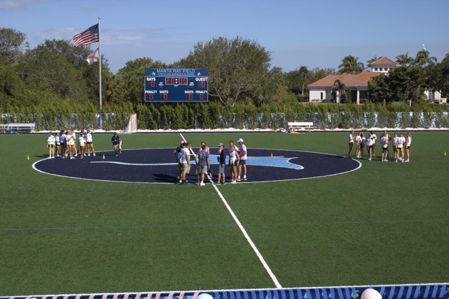 The coaches and referees meet at the middle of the Manta Ray Field while the crowd anxiously awaits the start of the game.