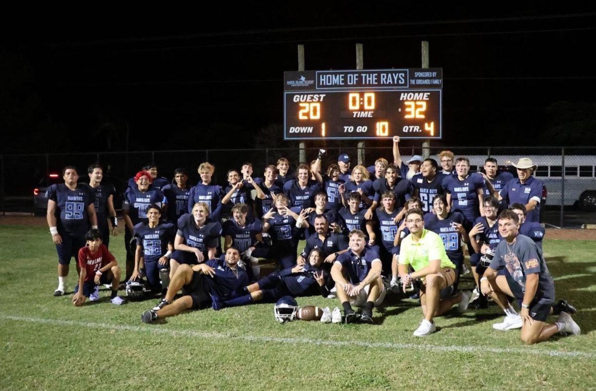 Rays Win! The MIA football team takes a picture in front of the scoreboard.