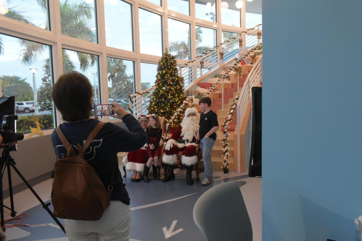 Children being photographed with Santa Claus and Mrs. Claus on the stairwell. 