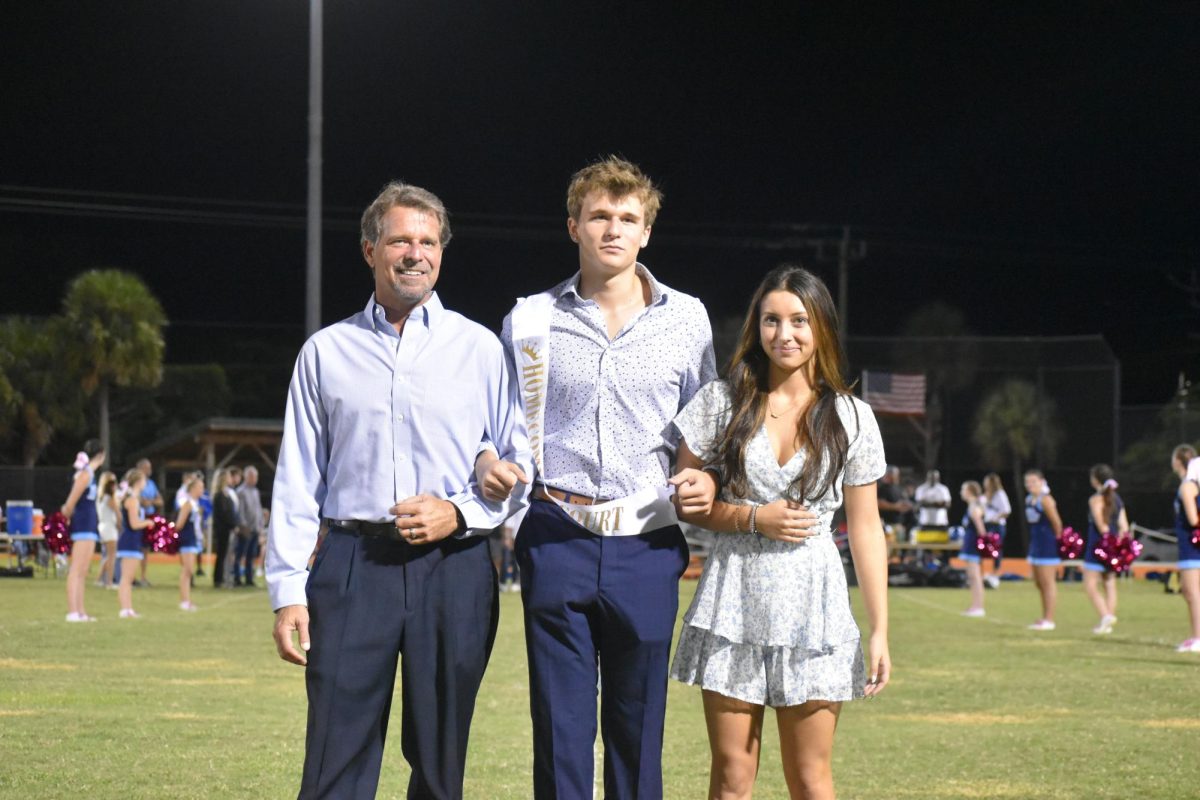 Junior homecoming court, Nate Romer accompanied by his father and girlfriend. 