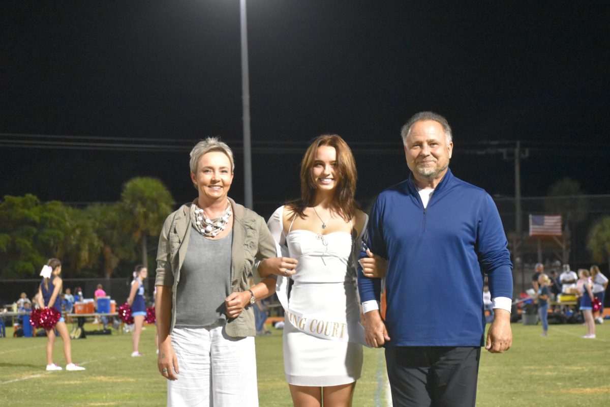 Senior homecoming court, Mia Winnik accompanied by her two parents. 
