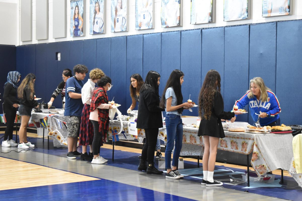 Students line the gym tasting homemade delicacies from all over the world.