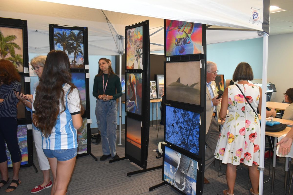 Students and visitors surrounded by student art at the showcase. 