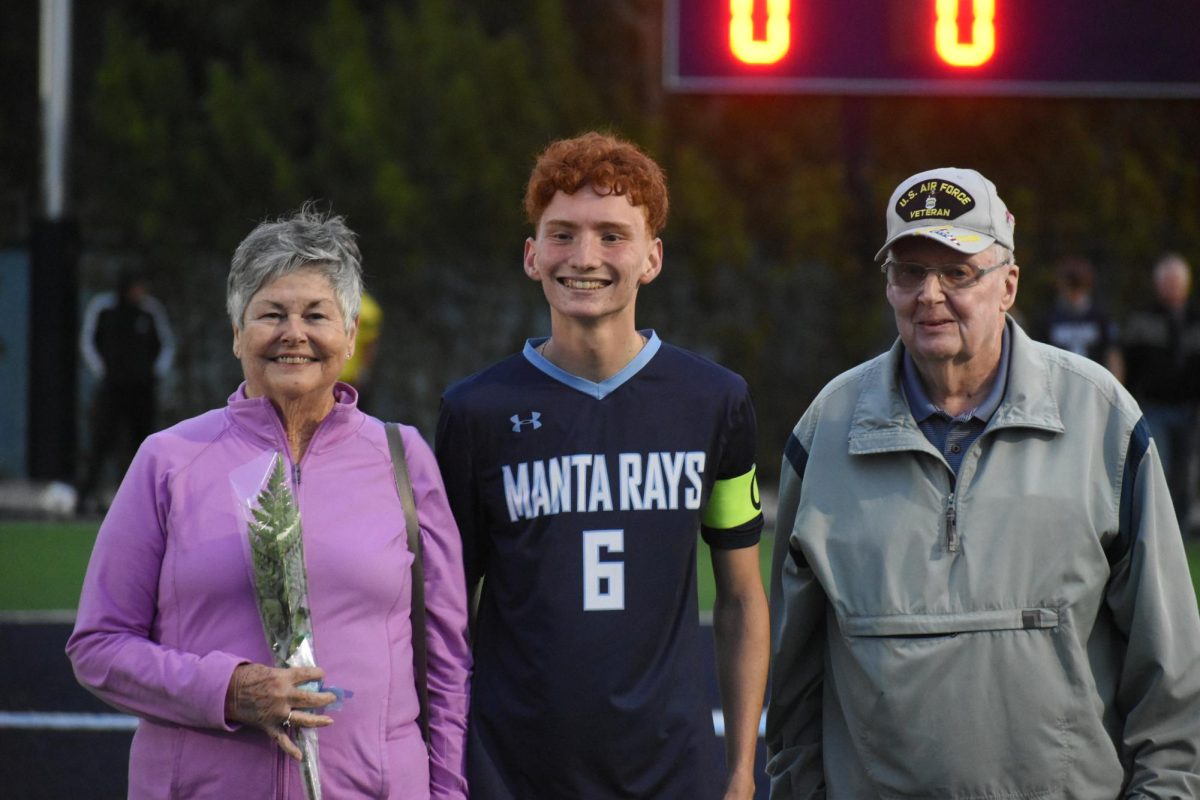 Ivan Harris being accompanied down the field by his grandparents. 