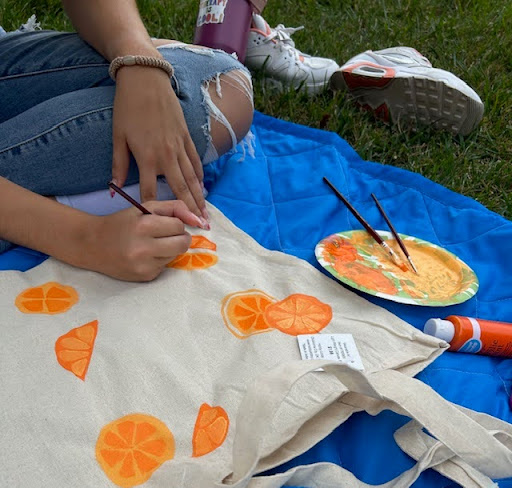 Acrylic painting tote bags on a picnic at the park. (Collette Combs)