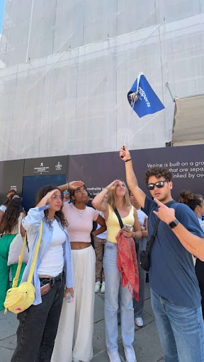 Image of Marco Island Academy students saluting the Passports flag in front of a ferry.