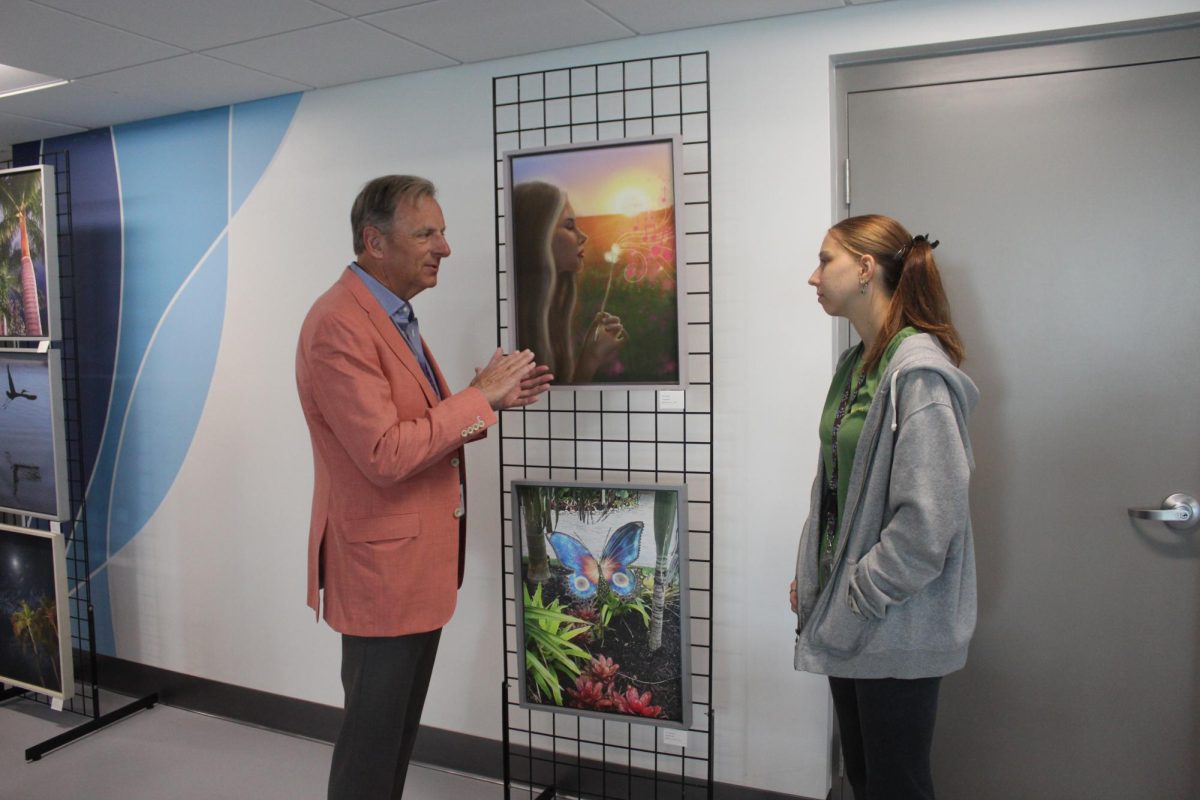 Junior Ella Riley discussing her art with donor Mark Melvin. 