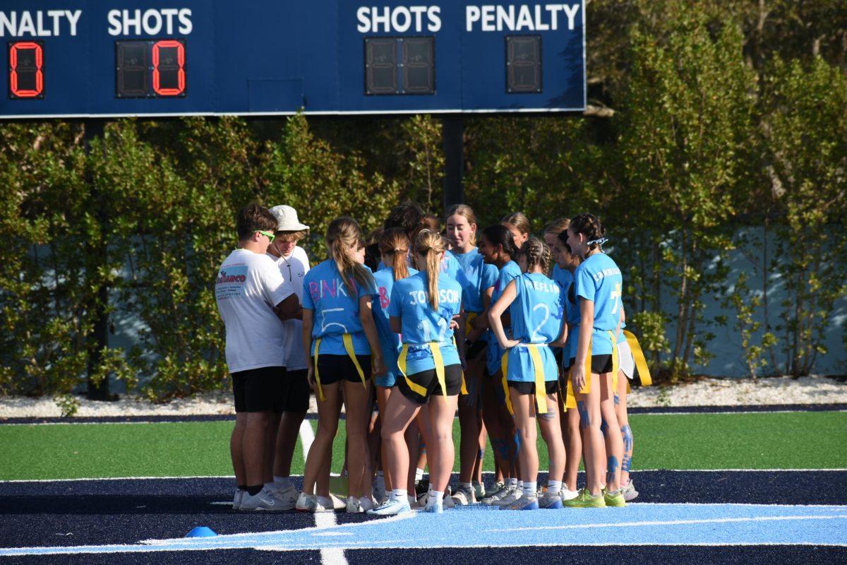 Blue team gathers in a huddle to prepare for their next play.