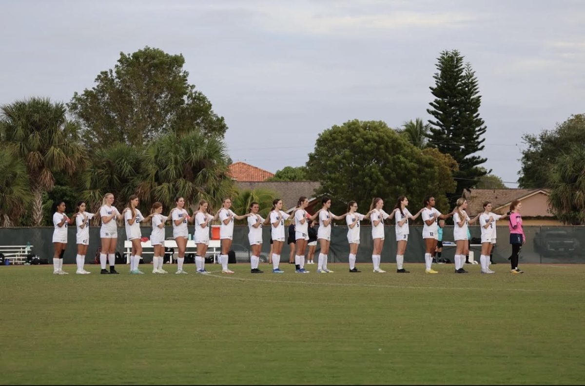 Marco Island Academy's girls soccer team stands united before a game.