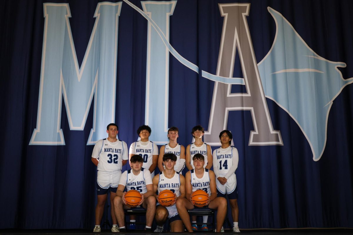 The varsity boys basketball team taking a team photo during media day. 