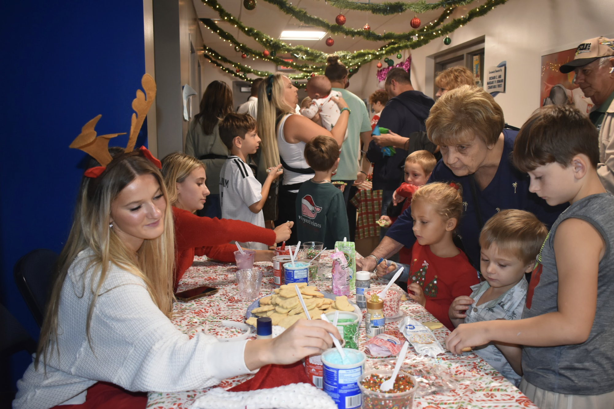 At the cookie-decorating table, Madi K. and Alessia S. helped guide kids as they decorate Christmas-shaped cookies with colorful frosting and sprinkles.