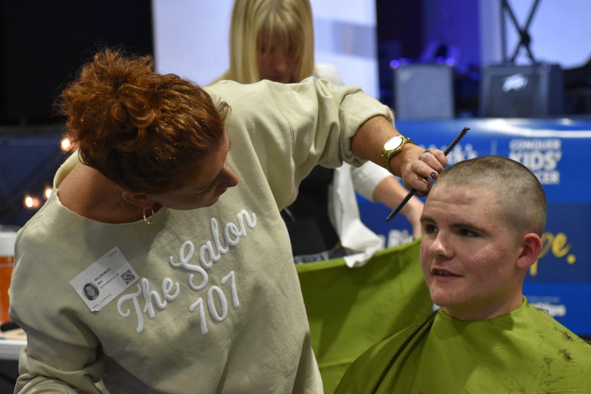 Freshman Kaiden Petit talks with barber Courtney Billingsley about his new hairstyle.